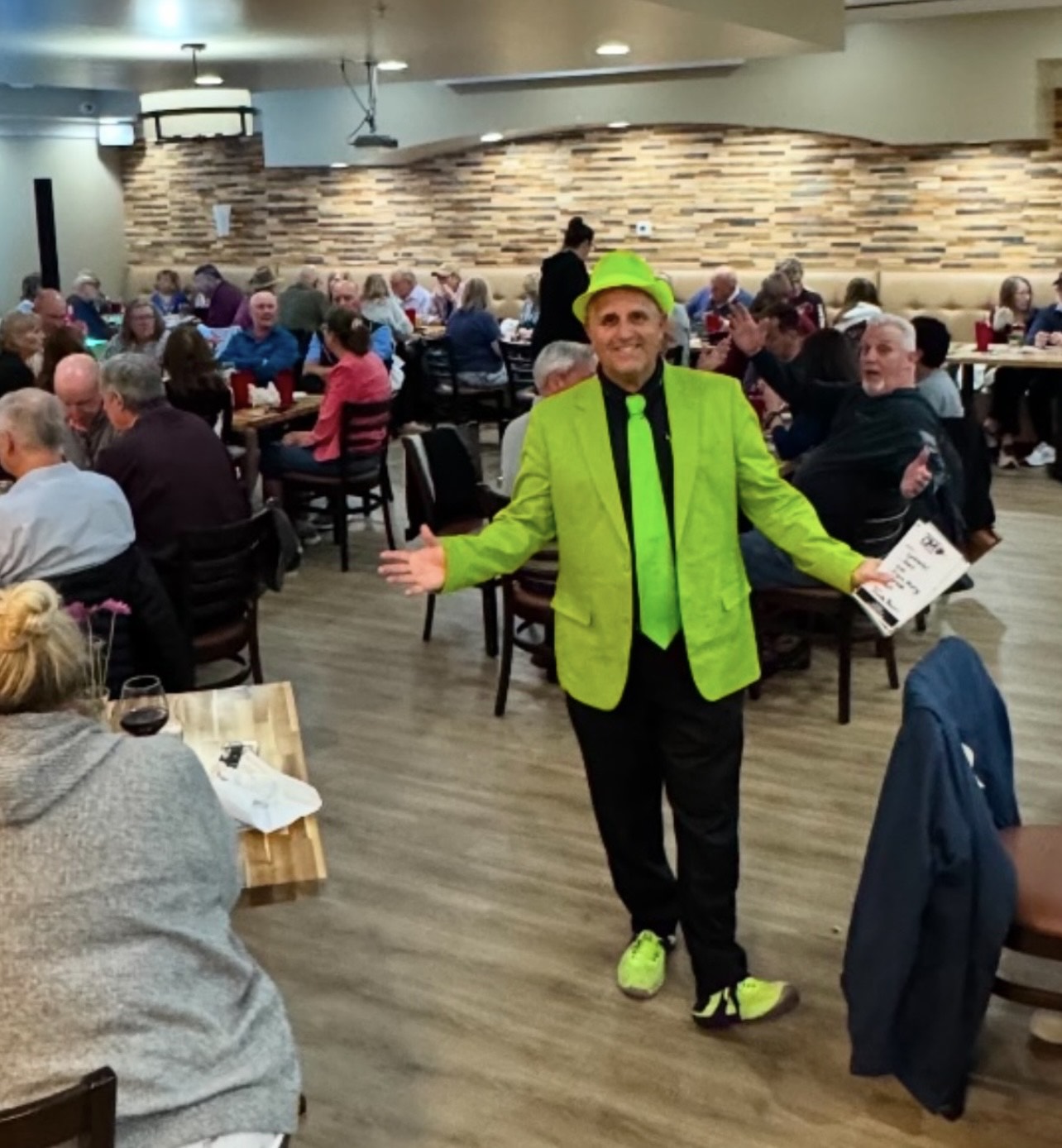 Mark Marino in notable outfit in front of guests and audience at a restaurant in Naples, Florida.