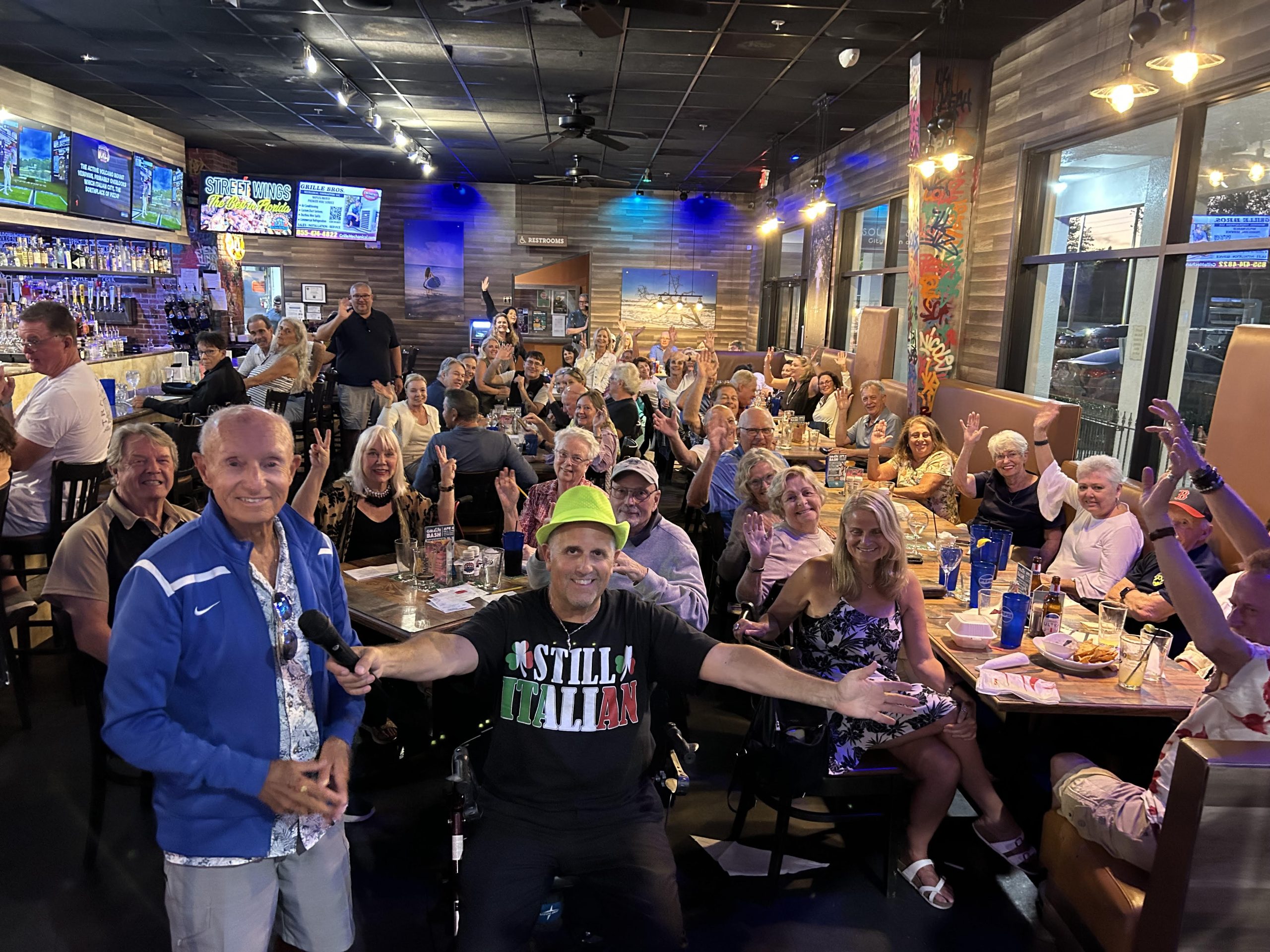 Question Maahk Trivia owner Mark Marino standing in front of a crowd at one of his restaurant locations.